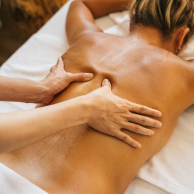 Close-up of a relaxing massage therapy session at a spa with focus on back and hands.
